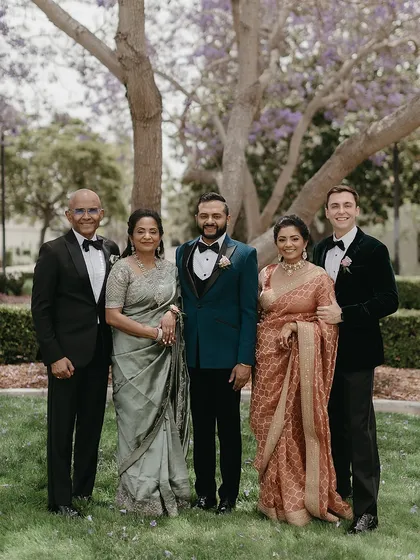 A portrait of the groom with his immediate family. This image highlights the color harmony we created, with the groom's teal jacket standing out against his mother's sage green, his sister's rusty rose gold, and his father's and brother-in-law's classic black tuxedos.