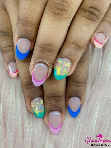 A colorful and playful French manicure with tips in shades of blue, pink, and teal, accented with a translucent bow design.