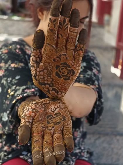 This design features bold rose motifs on the palms, surrounded by delicate, intricate patterns that extend up the arms.