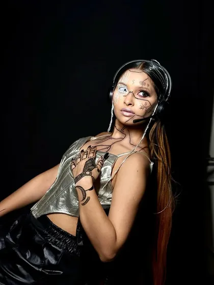Another perspective of the cyber glam look, playing with light and shadow to emphasize the metallic sheen and detailed line work. This is makeup as a form of storytelling.