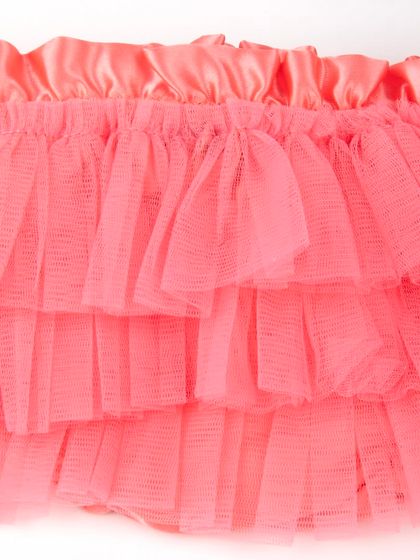 A macro shot of the layered tulle fabric on the coral skirt.