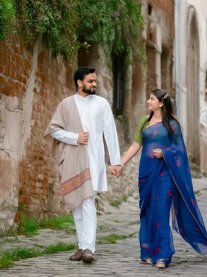 A candid shot of a couple walking hand-in-hand through a rustic city lane. This photo captures a natural, unposed moment that feels authentic and full of story.
