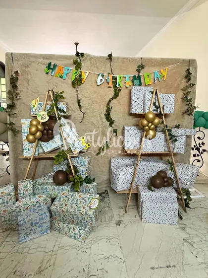 Even the gift station can be part of the theme. Here, presents are beautifully displayed with jungle-themed wrapping paper and rustic decor elements.
