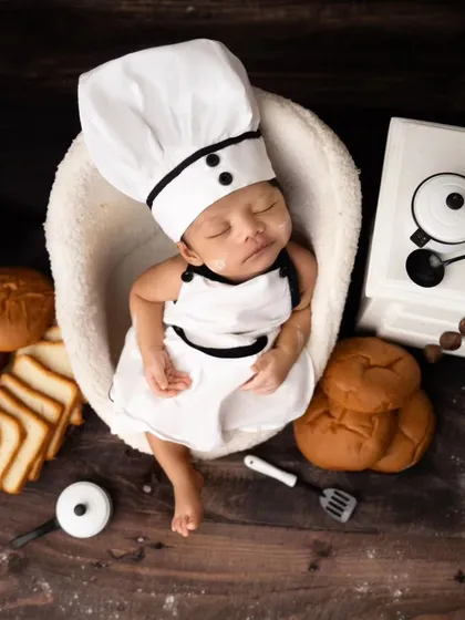 An overhead view of the little chef, surrounded by bread, mini kitchen utensils, and a tiny stove.