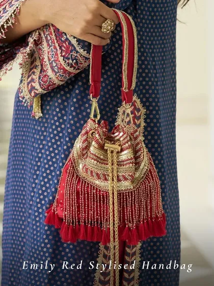 My Emily Red Stylised Handbag is the perfect accessory for traditional red outfits. The combination of red fabric, golden beadwork, and tassels makes it a festive essential for Karwa Chauth or a bridal trousseau.