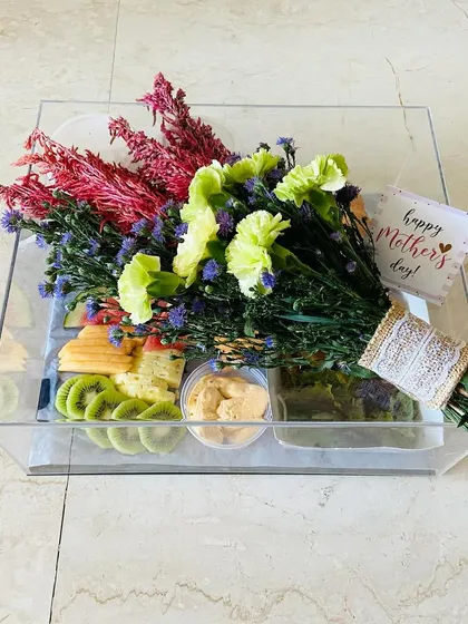 A Mother's Day pamper hamper designed for breakfast in bed. This acrylic tray holds a fresh bouquet, fruits, dip, and delicious baked goods.