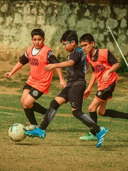 Three players are locked in a tight contest for the ball.