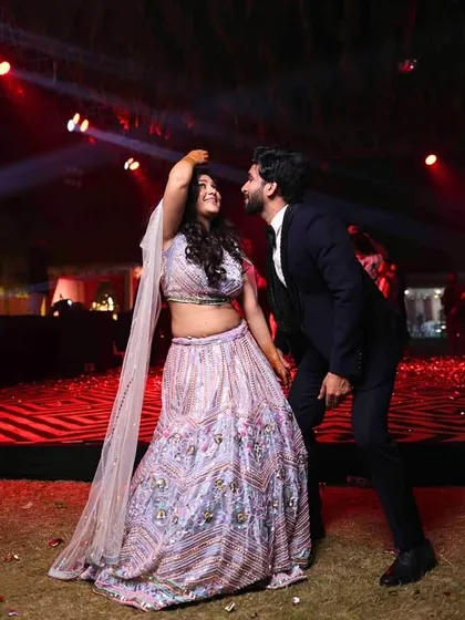 A candid moment on the dance floor. Amidst the high-energy party, the couple steals a moment for themselves, perfectly capturing the joy of their cocktail night.