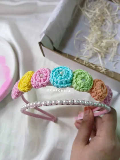 This shows the two parts of our floral tiara set. You get the crochet floral band and a separate simple pearl hairband that can be worn together or on their own.