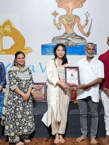 A student receives her certificate for the October Yoga Teacher Training course.