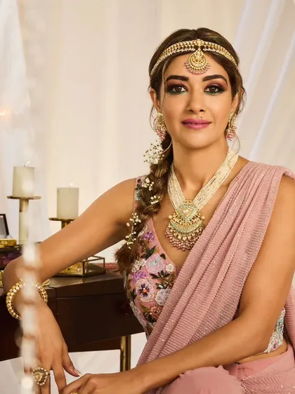 A bohemian-inspired bridal braid. This loose, textured braid is woven with baby's breath and paired with a sheeshpatti for a look that is perfect for a Mehendi or a relaxed outdoor wedding.