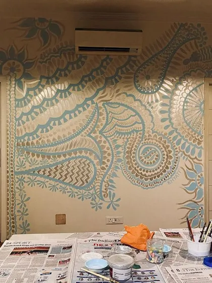 A view from my workstation while painting the Delhi mural. You can see my paints and brushes ready to go. The silver paint catches the light beautifully, adding a touch of magic to the wall.