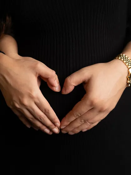 A simple, beautiful gesture. A mother's hands forming a heart over her baby bump is a universal symbol of love, protection, and the incredible bond she already shares with her child.