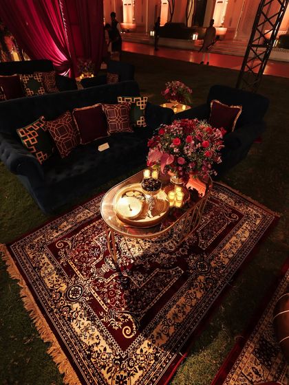 An overhead view of a lounge setup, showing how a beautiful Persian rug can define a space. The coffee table is styled with candles and florals, creating a cozy and inviting nook for guests.