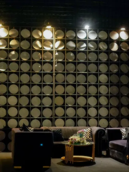 A unique, custom-designed wall feature with illuminated circular insets, creating a modern and artistic backdrop for one of the lounge areas.