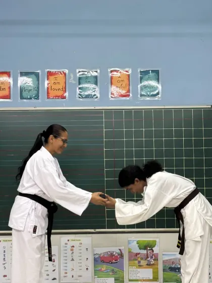 A student receives her Kuro-Obi (Black Belt), the result of years of consistent practice and perseverance. This moment represents not an end, but the true beginning of her journey in Karate-do.