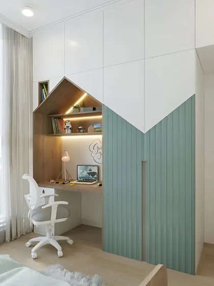 A dedicated study area is essential. We designed this clever house-shaped nook that combines a desk, shelving with integrated lighting, and a full-sized wardrobe, creating a functional and inspiring corner for learning.
