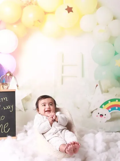 "I am halfway to one." This cheerful half-birthday session uses a rainbow and clouds theme to celebrate the six-month milestone. The baby's delighted expression shows just how much fun we have in the studio.