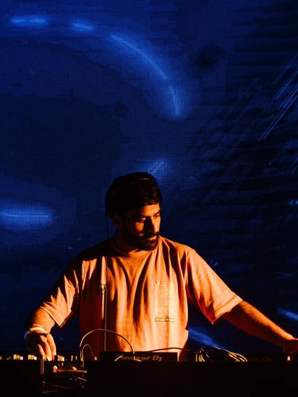 A moment of focus at the decks, with the blue glow of the visuals behind me. Every set is a chance to connect and create something special.