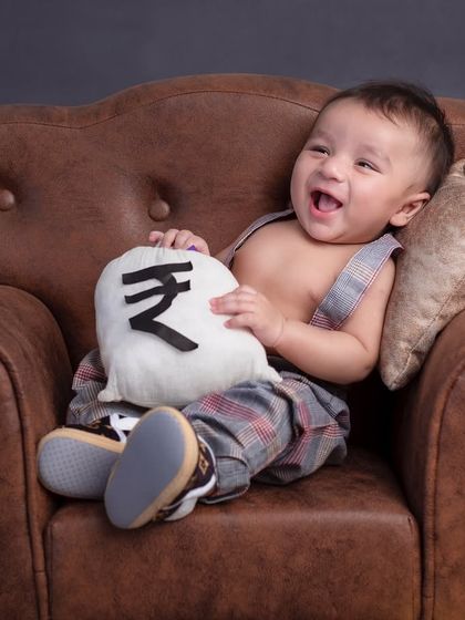 Paiso ki barish! This little boss baby is overjoyed with his bags of money, living the high life.