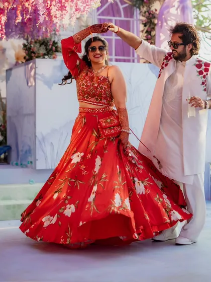 I love the energy of pre-wedding events! For this welcome party, we chose a vibrant red floral lehenga for the bride and a coordinated embroidered jacket for the groom. Their outfits were fun, comfortable for dancing, and perfectly captured the celebratory mood.