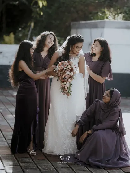 A beautiful moment between the bride and her bridesmaids, who are all gathered around her in their matching gowns.