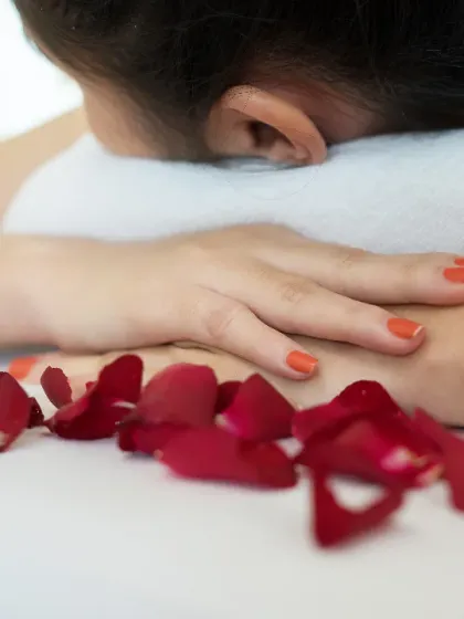 A moment of relaxation before a treatment. The rose petals scattered on the bed are a small touch to welcome you and begin your journey into serenity.