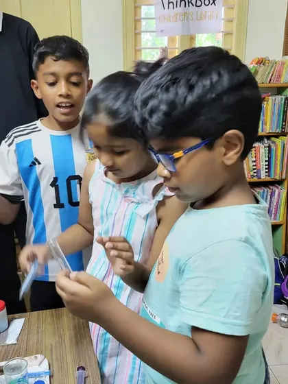 This is what curiosity looks like. Here, a group of young scientists are carefully observing the results of a chemistry experiment, learning together and sharing their discoveries.