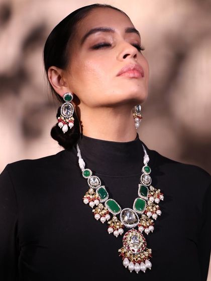 A stunning portrait for Qis by Ashmeet, with the model's eyes closed to draw full attention to the magnificent emerald and polki necklace.
