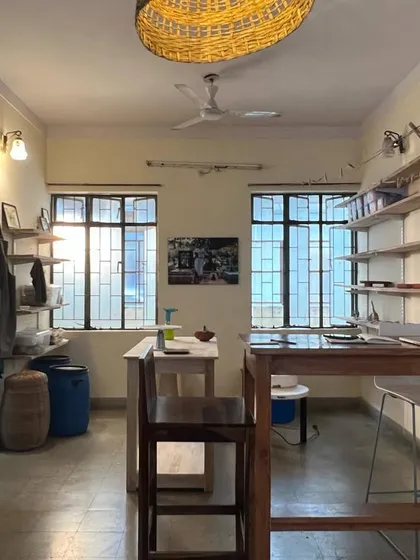 A wide view of our main studio area, filled with natural light from the large windows. The flexible wooden tables and open layout can be easily configured for workshops, exhibitions, photo shoots, or community gatherings.