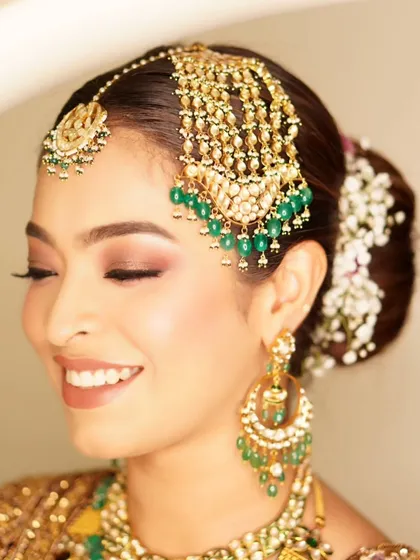 The joy of a wedding celebration is infectious. For the groom's sister, I designed a look that was both glamorous and traditional, with soft smokey eyes and a touch of glitter to beautifully complement her magnificent emerald jewelry. Her radiant smile says it all.
