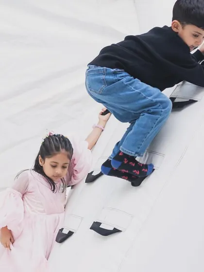 Kids work together to scale the small climbing wall inside our white bounce castle, a feature that adds an extra element of adventure.