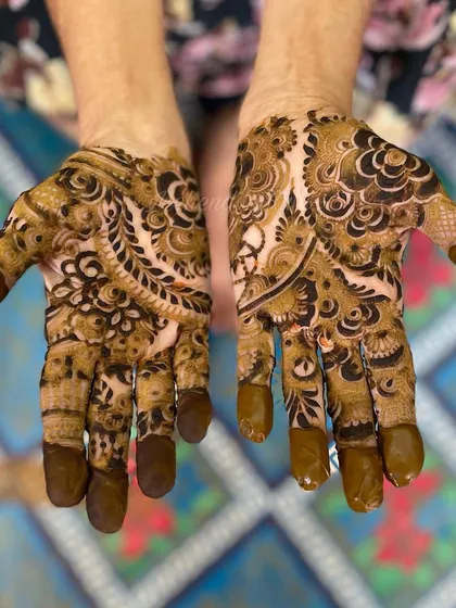 The palms of this floral design are just as detailed, with a mix of traditional paisleys and flowers. The solid fingertips complete this classic mehendi look.