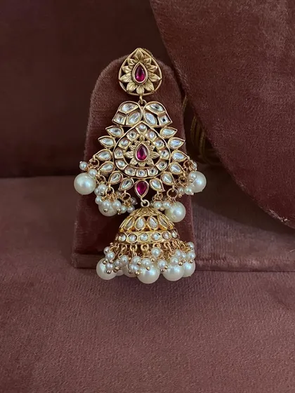 A detailed shot of the jhumka earring from the modern ruby set. You can see the quality of the stones and the pearl detailing.
