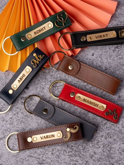 I offer a wide range of personalized keychains made from durable faux leather. This image displays several color options and charm designs, from cameras and bikes to simple initials, allowing for full customization.