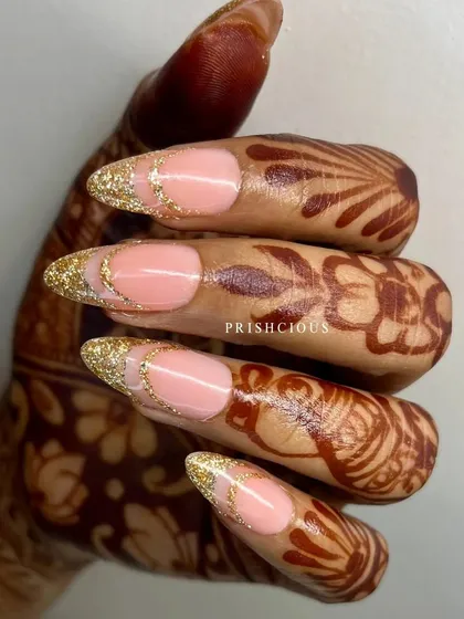 Golden elegance for this client's special day. This beautiful design features a glittery gold French tip that looks stunning against her henna.