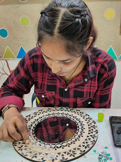A student working on a Lippan art piece, a traditional mural craft from Kutch, Gujarat. We teach how to create beautiful patterns with clay and mirrors.