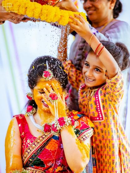 Another angle of the playful water and flower shower, capturing the bride's uninhibited happiness.