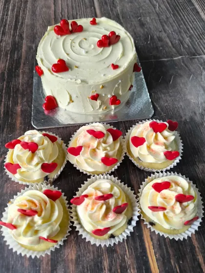 A classic expression of love. This set includes a simple white cake adorned with red hearts and matching cupcakes with buttercream swirls and tiny heart sprinkles.