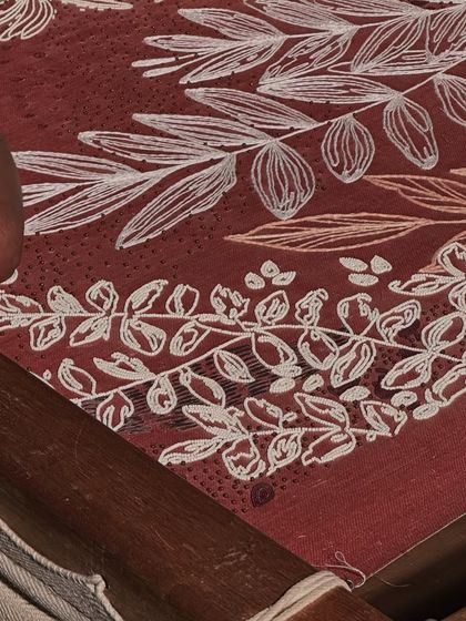 The process of creating our bespoke embroidered wallpaper. Here, you can see an artisan meticulously working on the floral pattern, a testament to the weeks of handwork that go into producing these exquisite, large-scale textile art pieces.