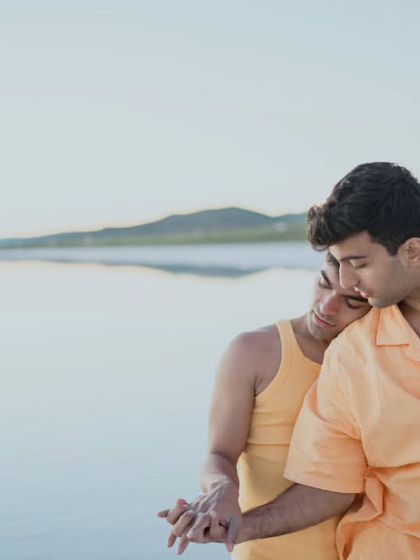 A tender and quiet moment between a couple on a Turkish beach. One partner rests their head on the other's shoulder, conveying a sense of comfort, trust, and deep affection.