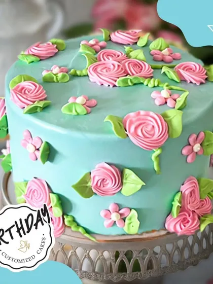 A beautiful floral cake with a pastel blue base and pink buttercream roses. This design is a lovely example of classic floral piping artistry.