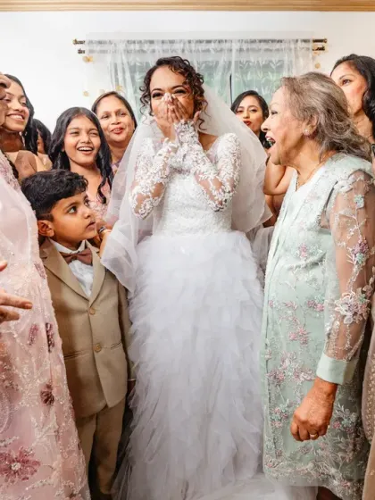 The bride's emotional reaction as she is surrounded by her family's love and blessings. The surprise and joy on her face is priceless.