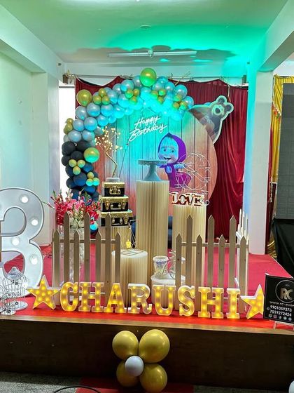 A fun Masha and the Bear theme for a third birthday. The stage includes character cutouts, a themed backdrop, and a large light-up number '3'.