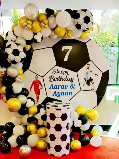 A football-themed 7th birthday party with a giant football backdrop, marquee number, and themed plinth.