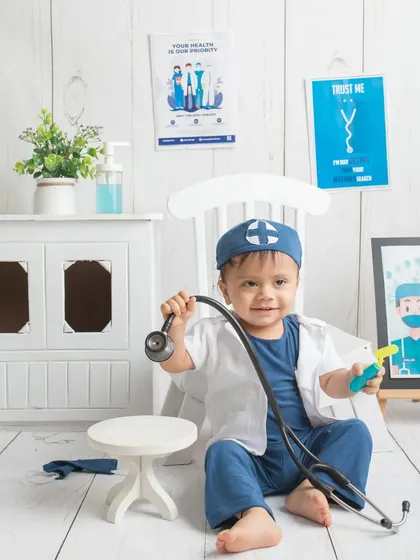 Posing with his medical tools. This themed shoot is a wonderful way to celebrate the profession of his parents and his own playful imagination.