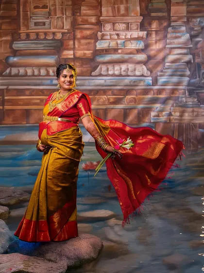 A powerful solo portrait against my custom temple-inspired studio backdrop. The rich colors of the silk saree and the dynamic toss of the pallu create a sense of celebration and divine femininity, perfect for a seemantham photoshoot.