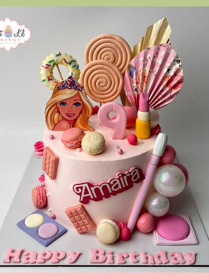 A Barbie and makeup-themed cake for Amaira's 9th birthday. This pink creation is loaded with edible lollipops, makeup brushes, and chocolate bars.