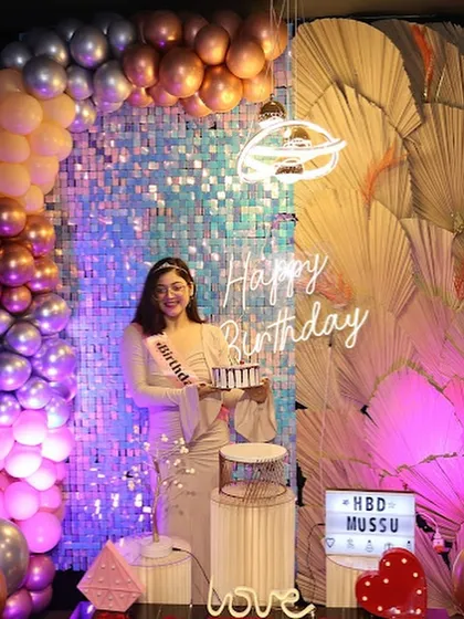 The birthday girl poses against a full backdrop of balloons and a sequin wall, showcasing the grand scale of our decorations. It's a setup designed to wow.