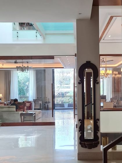 The entrance foyer of a multi level home, showcasing an open layout that draws the eye through different living zones. A grand clock and natural elements add character and warmth.